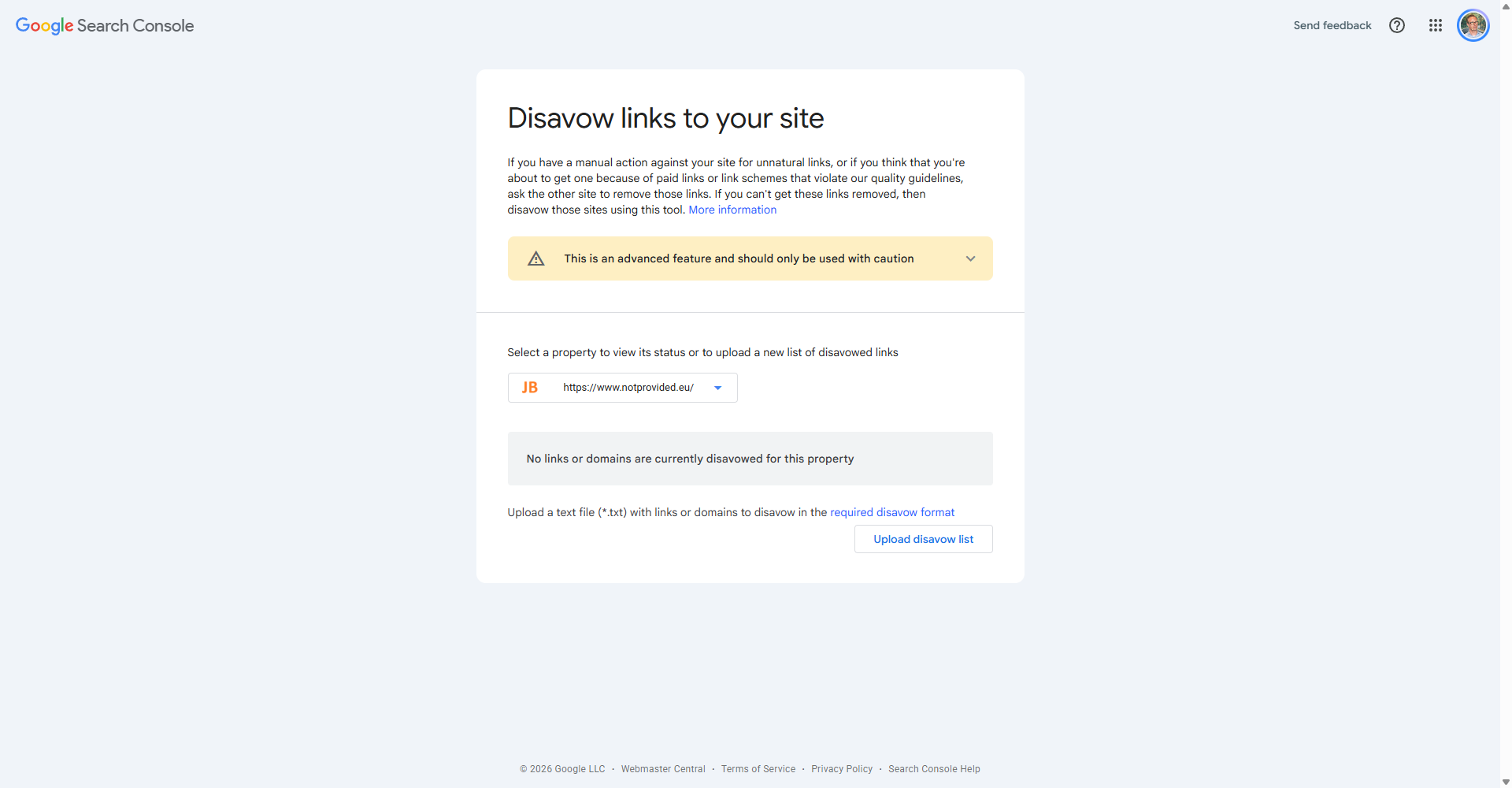 The Disavow links tool in Google Search Console with a URL-prefix property selected, a caution that it is an advanced feature, the message that no links or domains are currently disavowed, and the Upload disavow list button